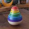 Mader wooden rainbow roly-poly wobbly pear toy placed on a walnut wood plate in the Babipur playroom.