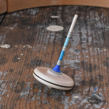 Mader Rainbow Spaghetti Spinning Top in blue placed on a desk in the Babipur playroom. 