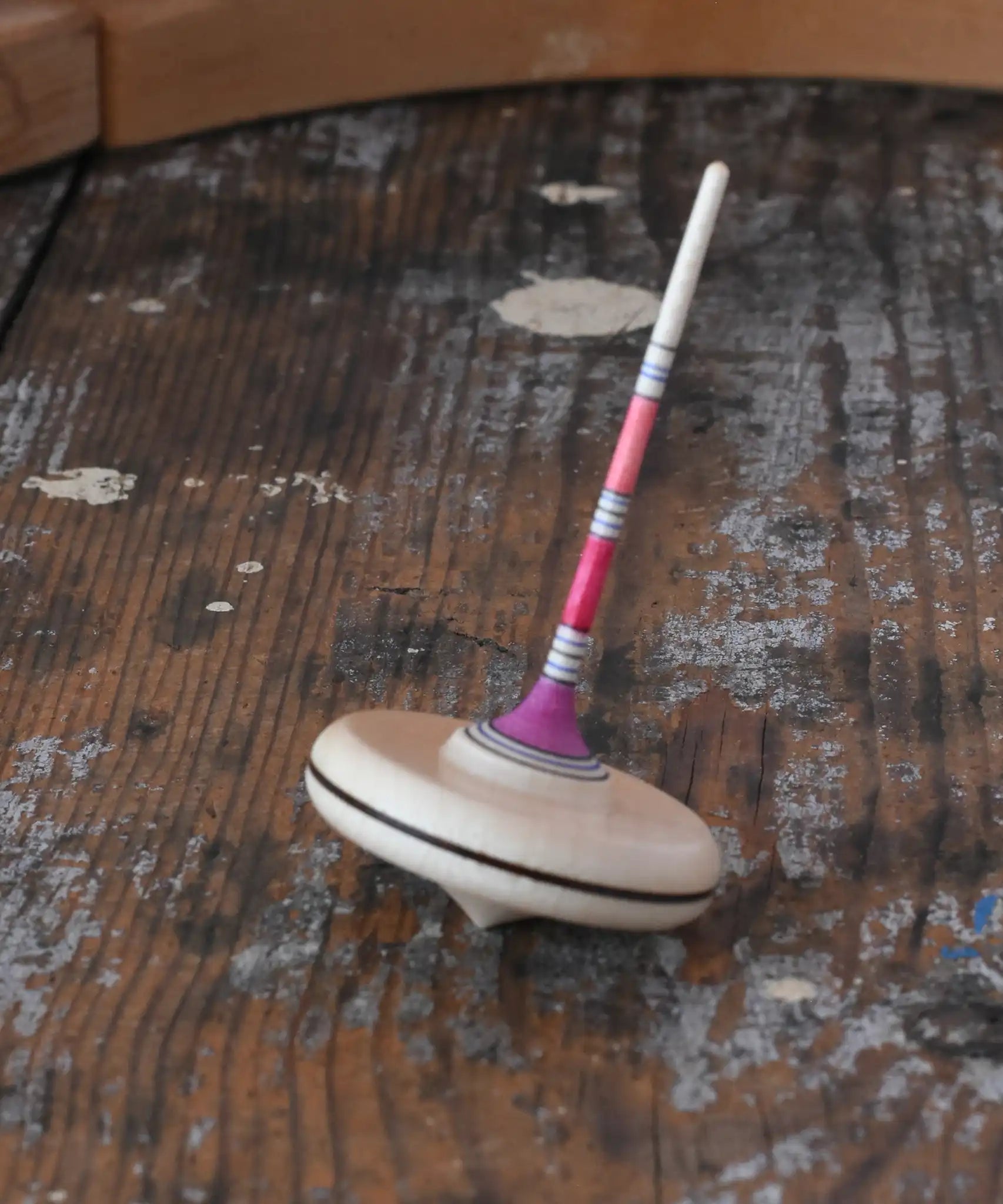 Mader Rainbow Spaghetti Spinning Top in placed on a desk in the Babipur playroom. 