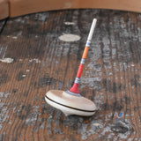 Mader Rainbow Spaghetti Spinning Top in placed on a desk in the Babipur playroom. 