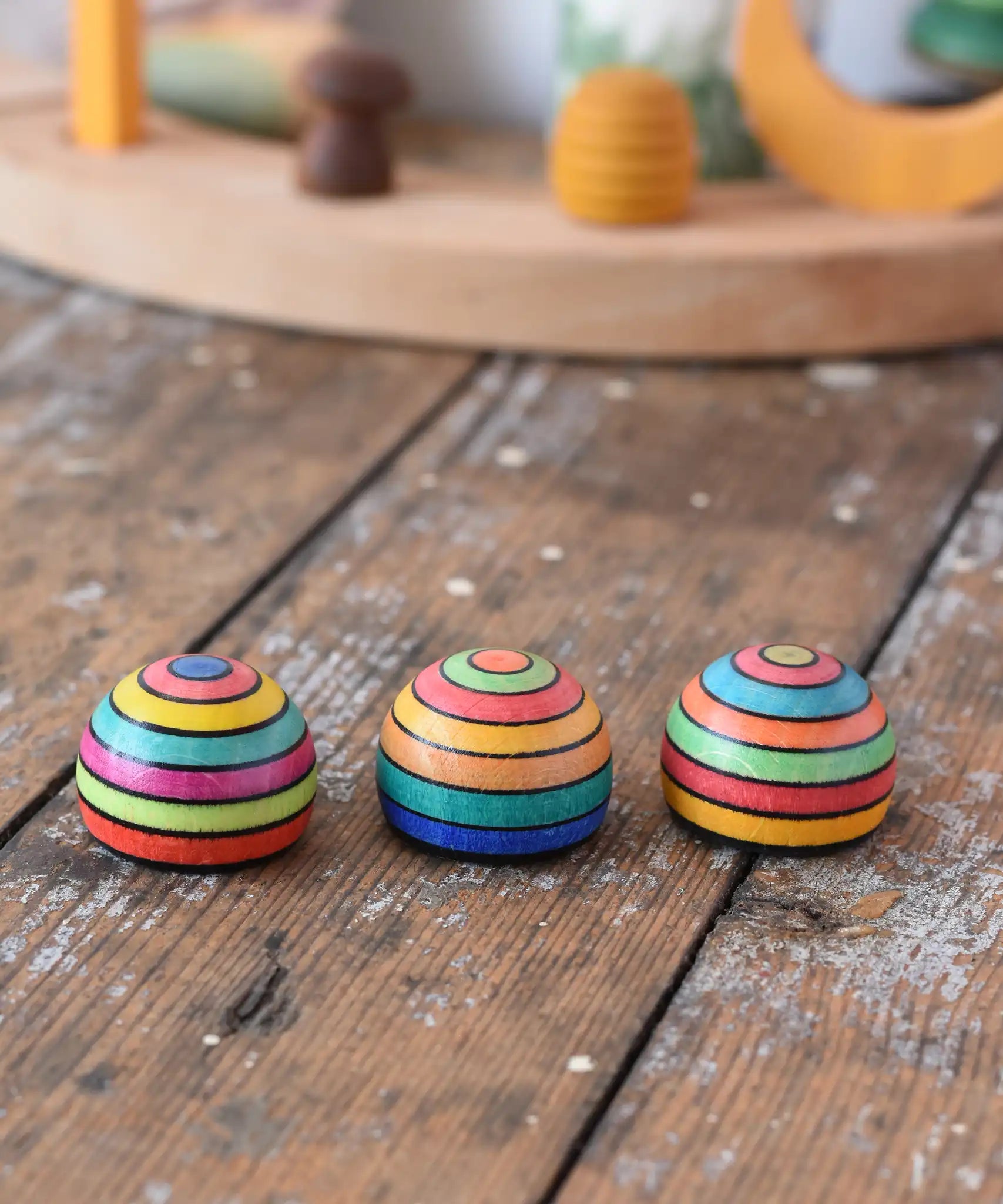 Three Mader striped wooden magnets placed on a desk in the Babipur playroom.
