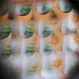 Mader Rainbow Kaleidoscope view through the lens of a tree spinning top and Grimm's moon decorative figure.