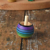 Mader Kreiselmanufaktur rainbow spinning turn-over top placed on a wooden desk in the Babipur playroom.