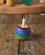 Mader Kreiselmanufaktur rainbow spinning turn-over top placed on a wooden desk in the Babipur playroom.
