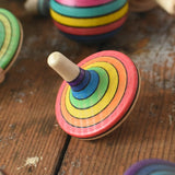 Mader Kreiselmanufaktur rainbow spinning top placed on a wooden surface in the Babipur playroom. 