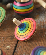 Mader Kreiselmanufaktur rainbow spinning top placed on a wooden surface in the Babipur playroom. 