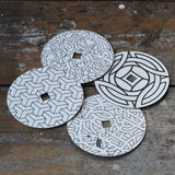 Mader patterned and coloured cardboard discs for 'So And So' Spinning Top placed on a wooden surface in the Babipur playroom. 