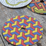 Mader patterned and coloured cardboard discs for 'So And So' Spinning Top placed on a wooden surface in the Babipur playroom. 
