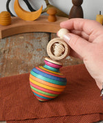 Mader Kreiselmanufaktur ring pull string spinning top placed on a cloth in the Babipur playroom.