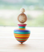 Mader Ring Spinning Top spinning in motion on a wooden surface in the Babipur playroom.