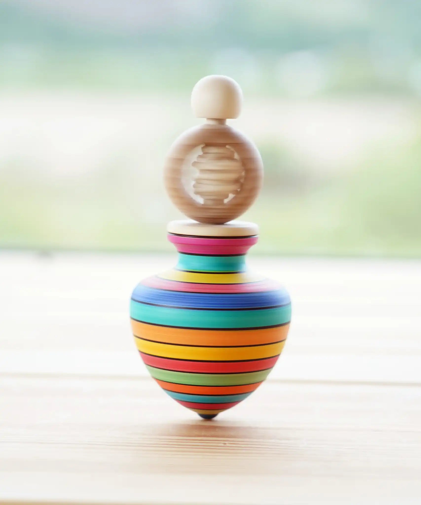 Mader Ring Spinning Top spinning in motion on a wooden surface in the Babipur playroom.