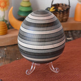 Mader Kreiselmanufaktur roly-poly wooden egg in graphite placed on the clear display stand in the Babipur playroom.