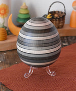 Mader Kreiselmanufaktur roly-poly wooden egg in graphite placed on the clear display stand in the Babipur playroom.