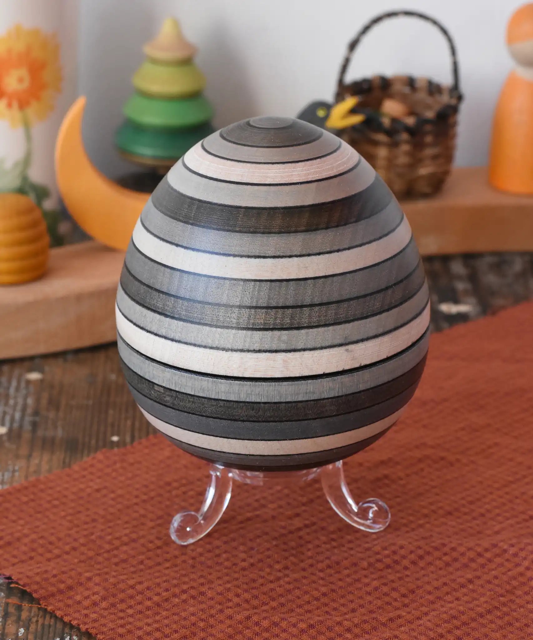 Mader Kreiselmanufaktur roly-poly wooden egg in graphite placed on the clear display stand in the Babipur playroom.