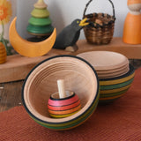 Mader Kreiselmanufaktur roly-poly wooden egg in green opened with a rainbow turn-over spinning top placed inside in the Babipur playroom.