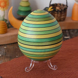 Mader Kreiselmanufaktur roly-poly wooden egg in green placed on the clear display stand in the Babipur playroom.
