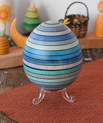 Mader Kreiselmanufaktur roly-poly wooden egg in ice blue placed on the clear display stand in the Babipur playroom.