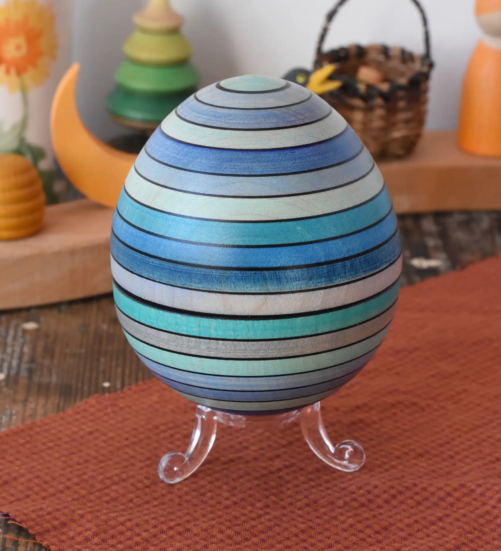 Mader Kreiselmanufaktur roly-poly wooden egg in ice blue placed on the clear display stand in the Babipur playroom.