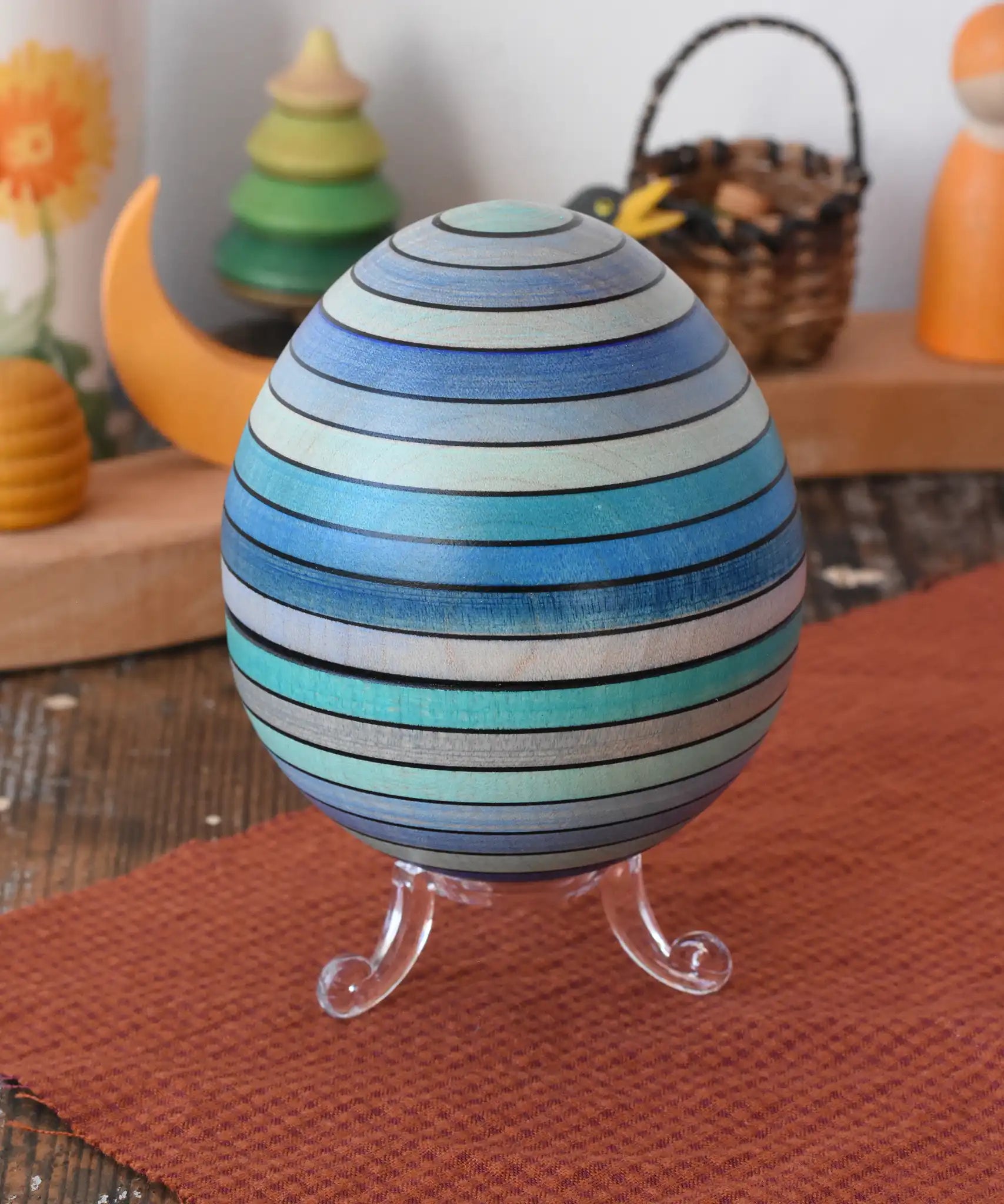 Mader Kreiselmanufaktur roly-poly wooden egg in ice blue placed on the clear display stand in the Babipur playroom.
