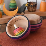 Mader Kreiselmanufaktur roly-poly wooden egg in graphite opened with a rainbow turn-over spinning top placed inside in the Babipur playroom.