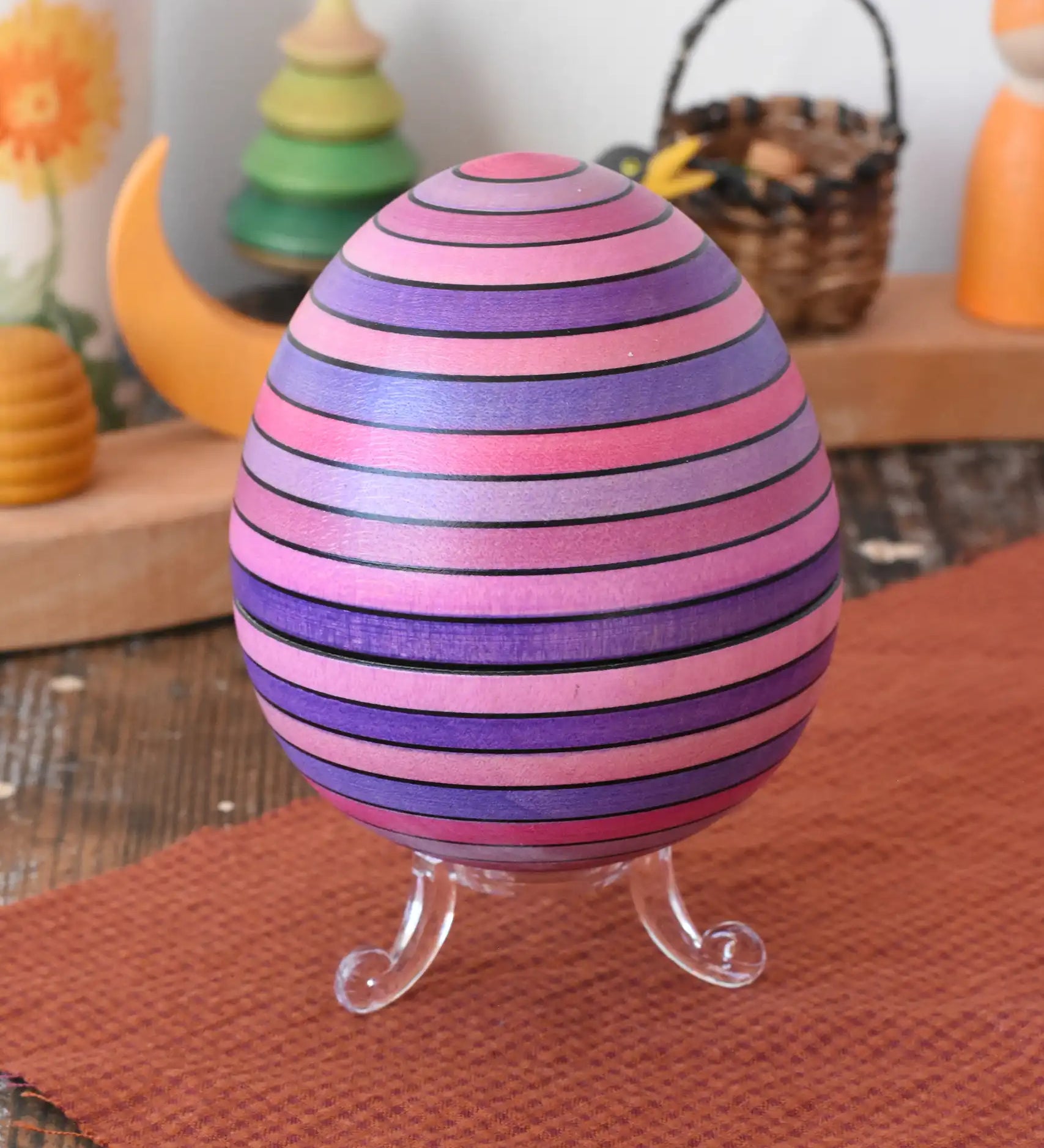 Mader Kreiselmanufaktur roly-poly wooden egg in lilac placed on the clear display stand in the Babipur playroom.