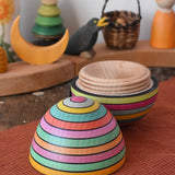 Mader Kreiselmanufaktur roly-poly wooden egg in Spring opened and placed on a wooden surface in the Babipur playroom. The wooden thread can be seen on the sides of the egg.
