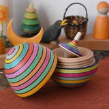 Mader Kreiselmanufaktur roly-poly wooden egg in Spring opened with a rainbow rallye spinning top placed inside in the Babipur playroom.