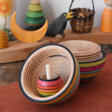 Mader Kreiselmanufaktur roly-poly wooden egg in Spring opened with a rainbow turn over spinning top placed inside in the Babipur playroom.