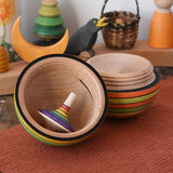 Mader Kreiselmanufaktur roly-poly wooden egg in Summer colours opened with a rainbow rallye spinning top placed inside in the Babipur playroom.