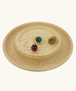 Mader Kreiselmanufaktur Rondell Ash Wood 40cm Spinning Plate with three wooden spinning tops placed on it.
