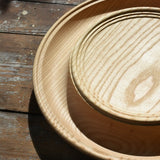 Close up of the Mader Kreiselmanufaktur Rondell Ash Wood 40cm Spinning Plate placed on a wooden surface in the Babipur playroom.