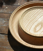 Close up of the Mader Kreiselmanufaktur Rondell Ash Wood 40cm Spinning Plate placed on a wooden surface in the Babipur playroom.