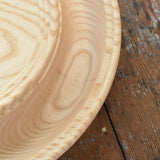 Close up of the Mader Kreiselmanufaktur Rondell Ash Wood 40cm Spinning Plate placed on a wooden surface in the Babipur playroom.