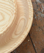 Close up of the Mader Kreiselmanufaktur Rondell Ash Wood 40cm Spinning Plate placed on a wooden surface in the Babipur playroom.