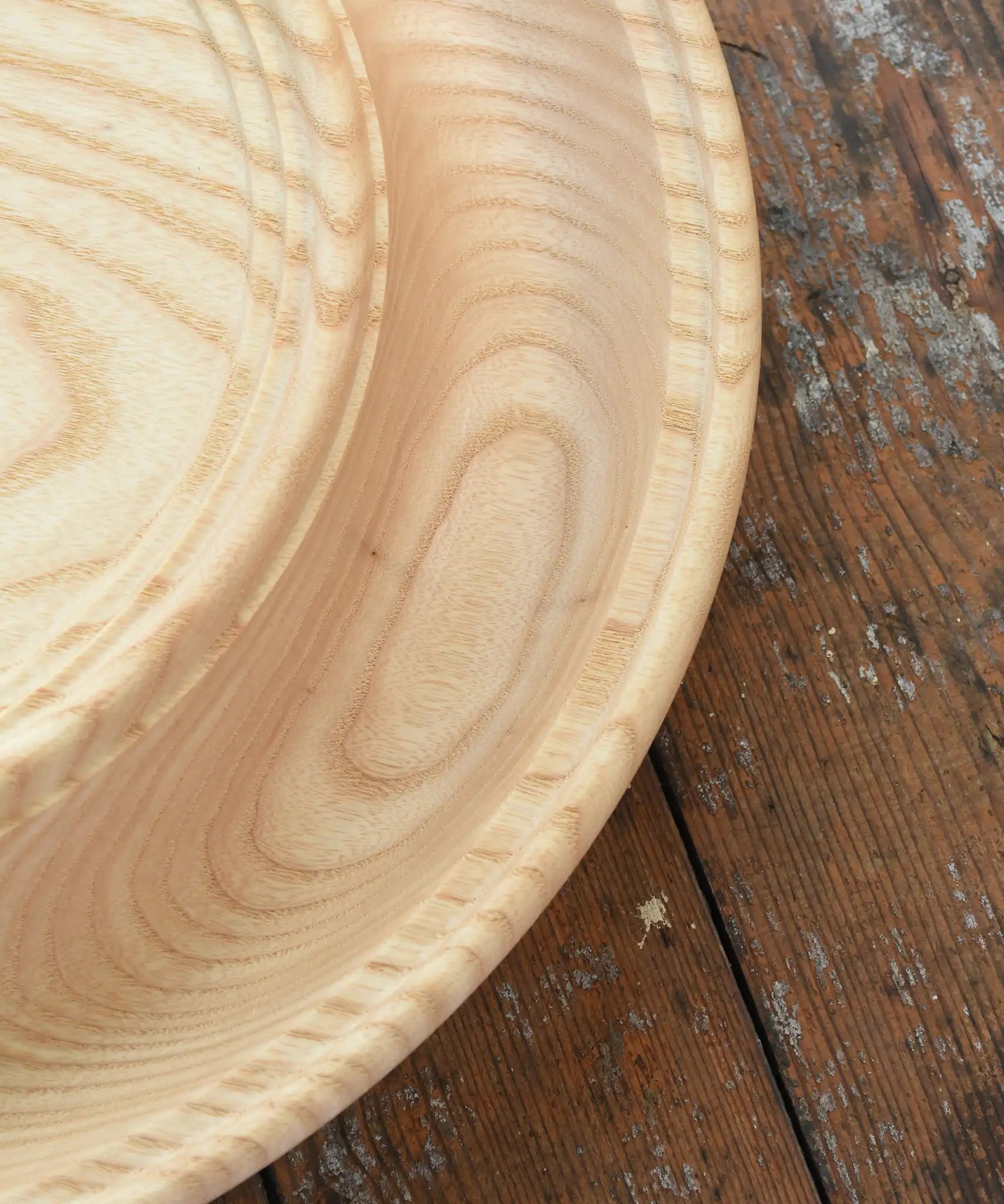 Close up of the Mader Kreiselmanufaktur Rondell Ash Wood 40cm Spinning Plate placed on a wooden surface in the Babipur playroom.