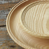Close up of the Mader Kreiselmanufaktur Rondell Ash Wood 40cm Spinning Plate placed on a wooden surface in the Babipur playroom.