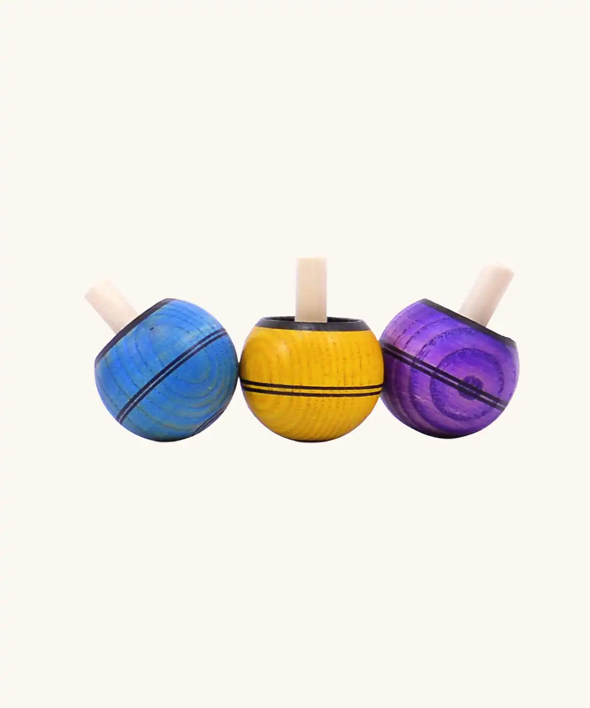 Three Mader Kreiselmanufaktur round ash turn over spinning top toys in various colours. Blue, yellow and purple.