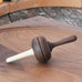Mader Kreiselmanufaktur Salto Totale Walnut / Hornbeam Spinning Top placed on a walnut wood spinning plate in the Babipur playroom.