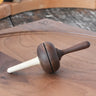Mader Kreiselmanufaktur Salto Totale Walnut / Hornbeam Spinning Top placed on a walnut wood spinning plate in the Babipur playroom.