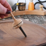 Mader Salto Totale wooden spinning top held upright on a walnut spinning plate in the Babipur playroom.