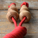 Close up of top pf the handles on the Mader Kreiselmanufaktur Children's Skipping Rope with Natural Handles placed on a wooden surface in the Babipur playroom. 