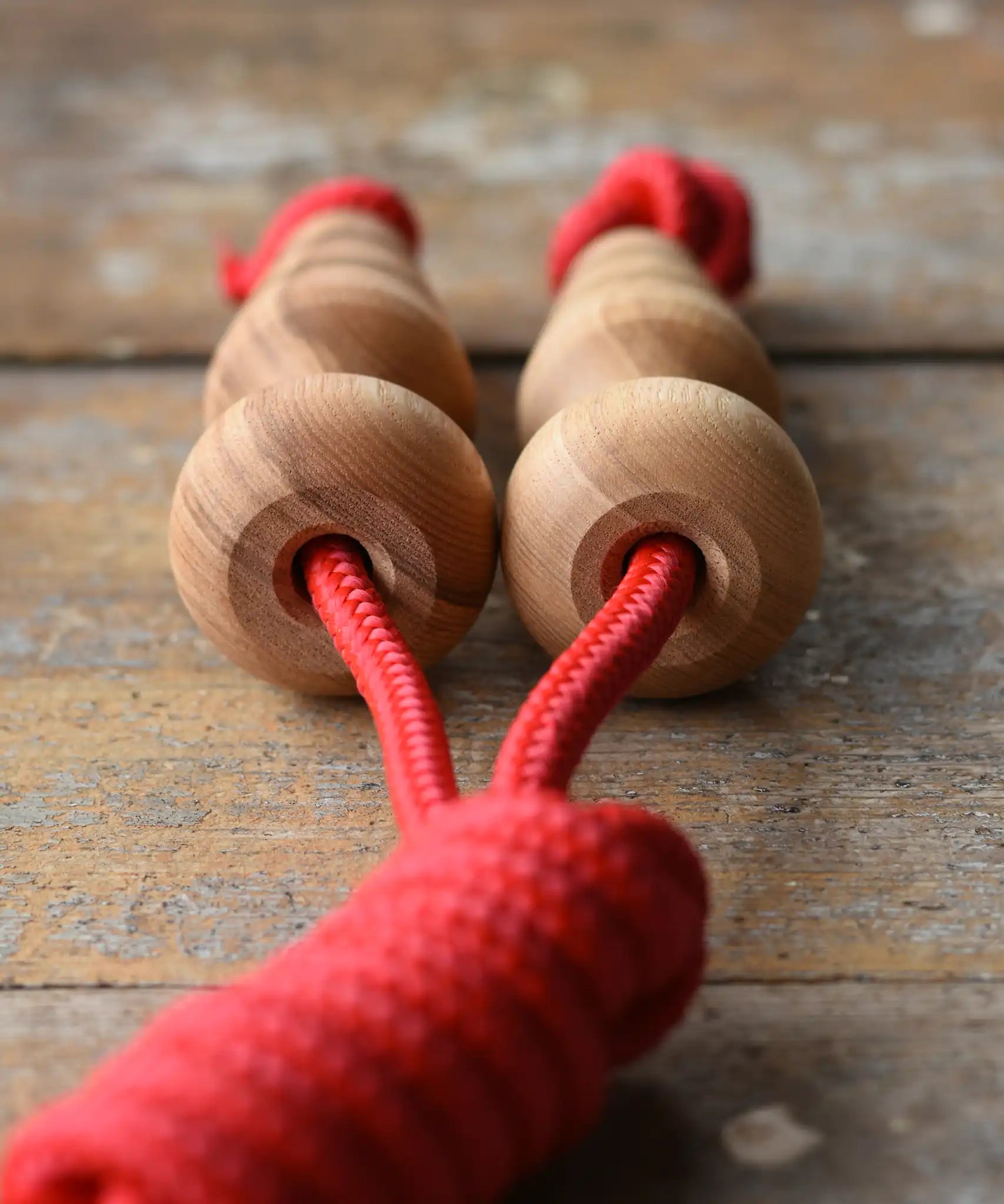 Close up of top pf the handles on the Mader Kreiselmanufaktur Children's Skipping Rope with Natural Handles placed on a wooden surface in the Babipur playroom. 