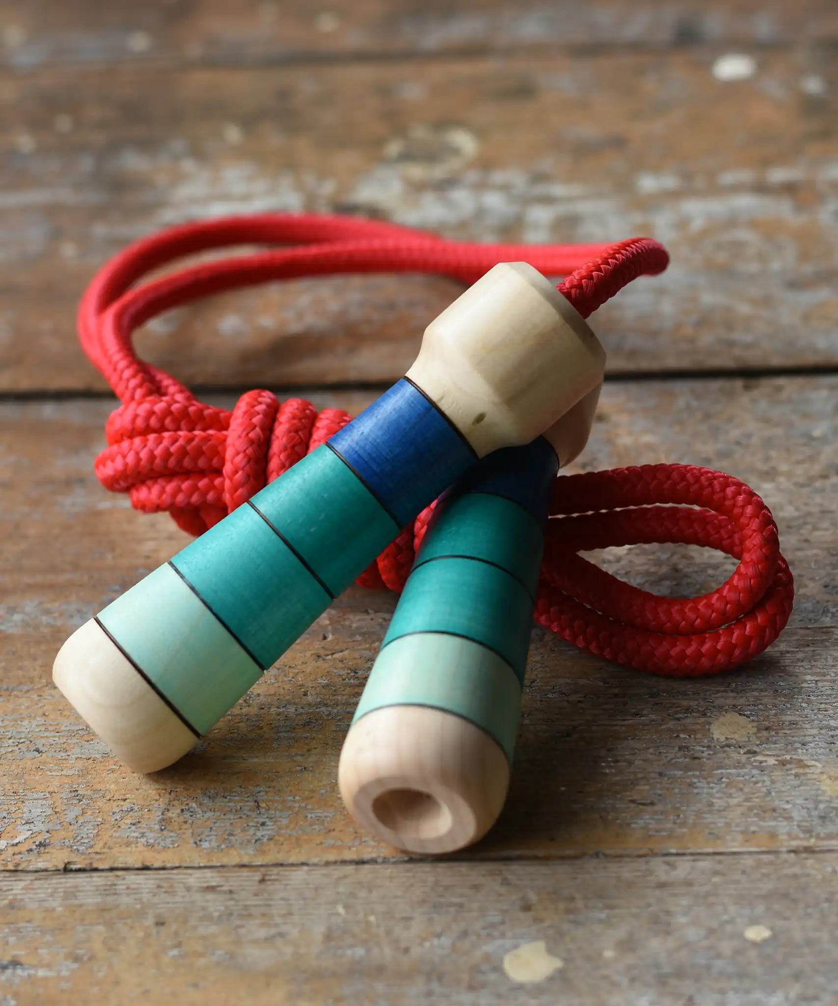 Mader Skipping Rope with Blue Handles placed on a wooden board in the Babipur playroom.