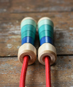 Close up of top of the handles on the Mader Skipping Rope with Blue Handles placed on a wooden board in the Babipur playroom.