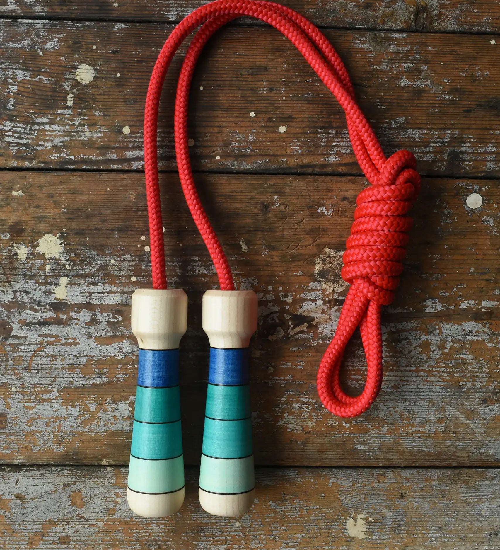 Mader Skipping Rope with Blue Handles placed on a wooden board in the Babipur playroom.