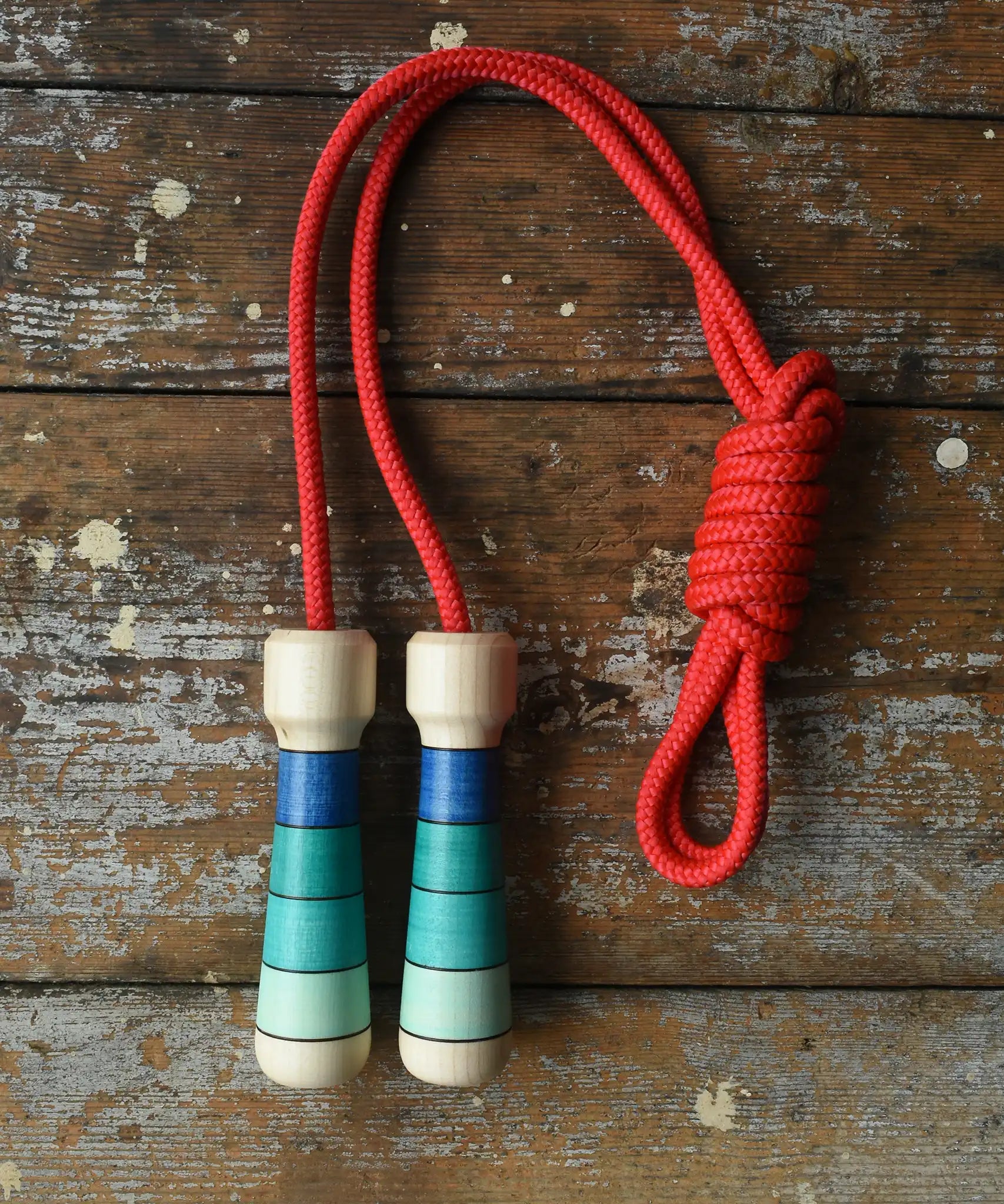Mader Skipping Rope with Blue Handles placed on a wooden board in the Babipur playroom.