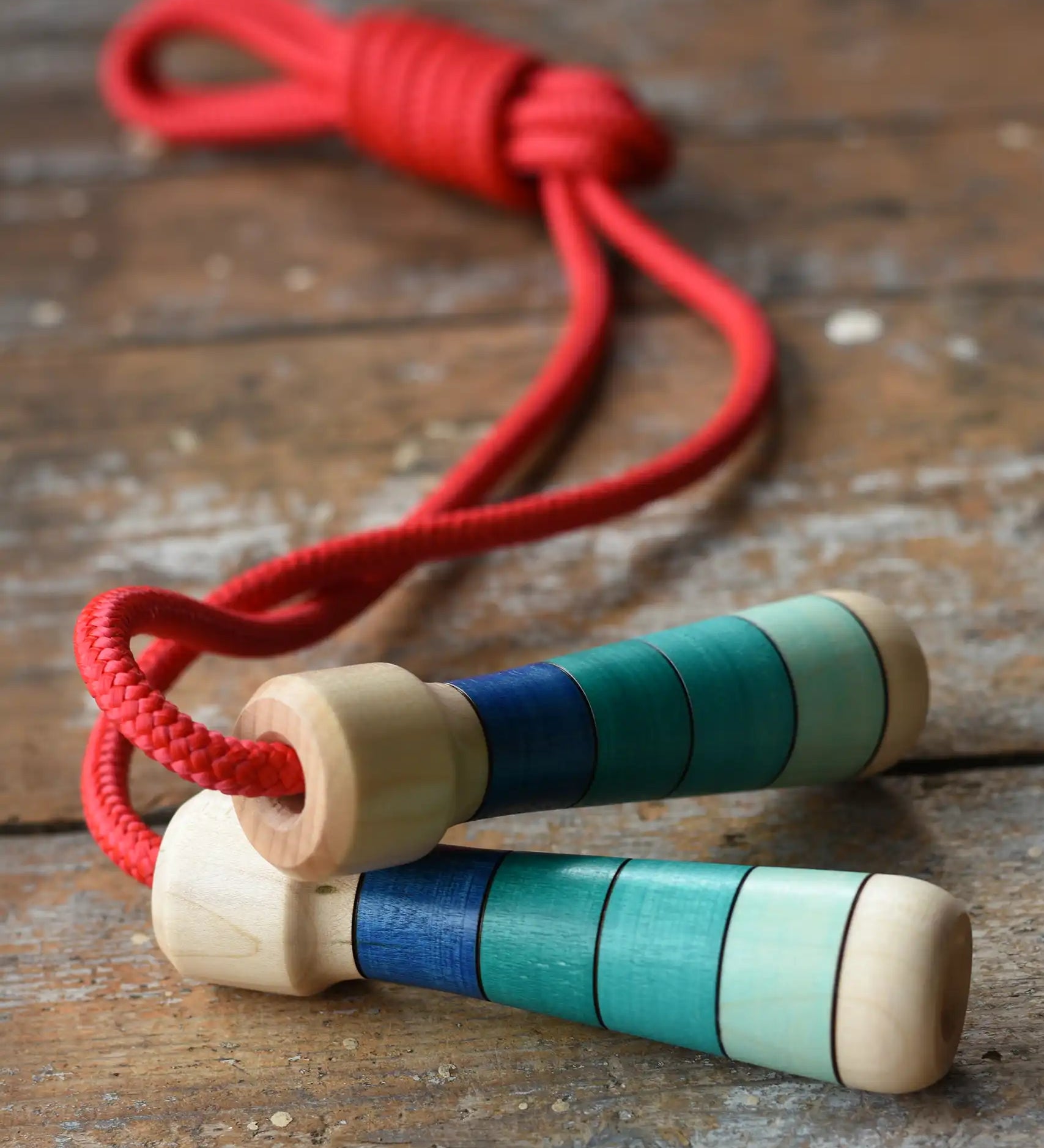 Mader Skipping Rope with Blue Handles placed on a wooden board in the Babipur playroom.