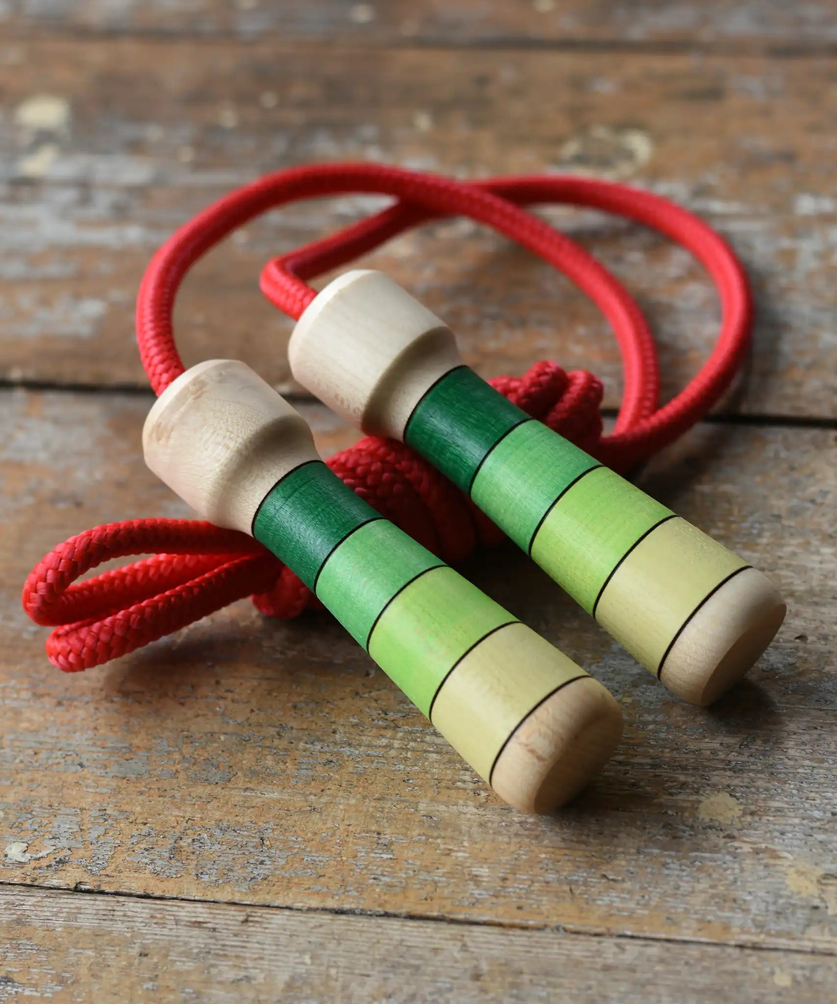 Mader Skipping Rope with Green Handles placed on a wooden board in the Babipur playroom. 