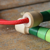 Close up of handle tops on the Mader Skipping Rope with Green Handles placed on a wooden board in the Babipur playroom. 