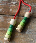 Mader Skipping Rope with Green Handles placed on a wooden board in the Babipur playroom. 